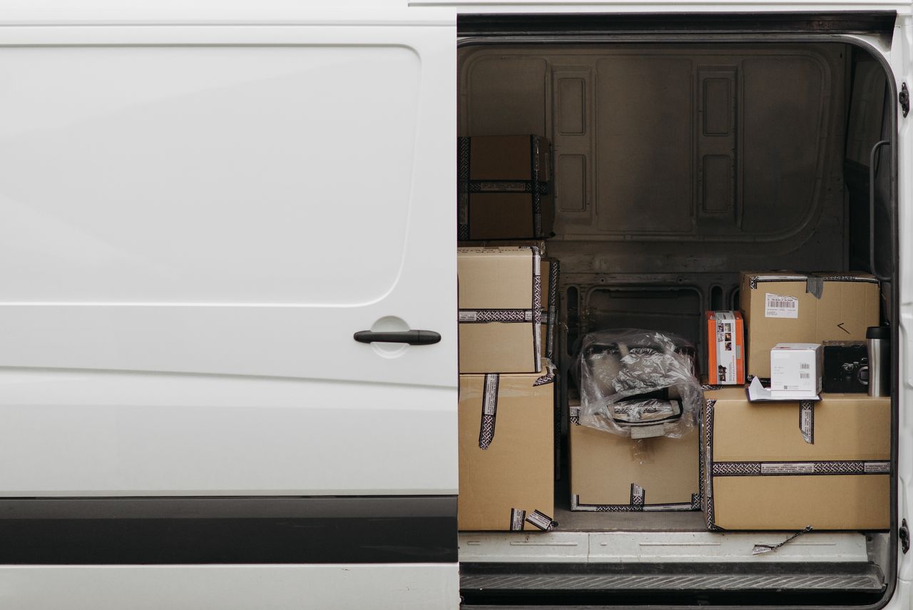 Open delivery van filled with boxes, ready for logistics and transport services.